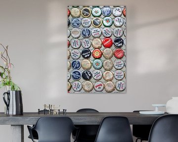 Bonte verzameling beer bottle caps geplakt op een muur van Tony Vingerhoets