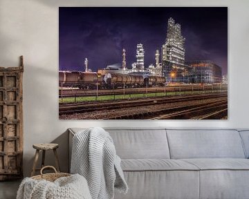 Row of train wagons with oil refinery against a purple sky by Tony Vingerhoets