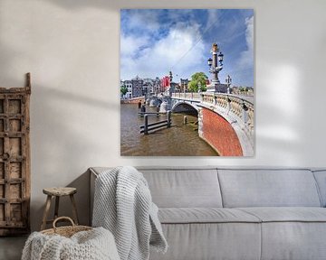 Oude brug tegen een blauwe bewolkte hemel in Amsterdam van Tony Vingerhoets