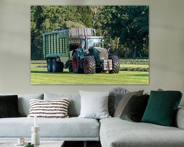 Grüner Traktor holt im Sommer in den Niederlanden geschnittenes Gras ab von Tonko Oosterink