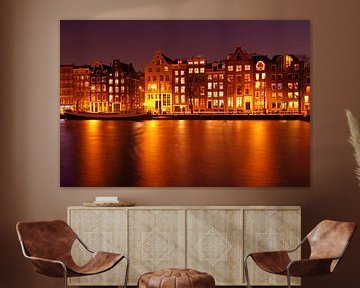 Middeleeuwse huizen aan de Amstel in Amsterdam bij nacht van Eye on You