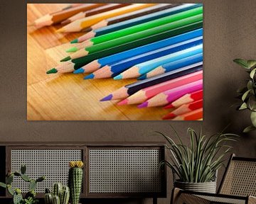 Kleurrijke potloden op een houten tafel van Henny Hagenaars
