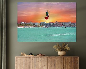 Un cerf-volant de surf saute sur Palm Beach à Aruba avec le coucher du soleil sur Eye on You