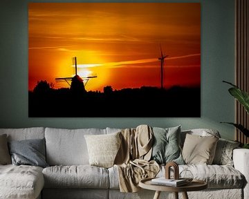Een oude en nieuwe windmolen met een zonsondergang van Jan Hermsen