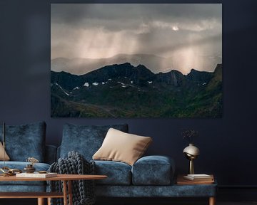Lichtstralen door de regen over de bergen van Axel Weidner