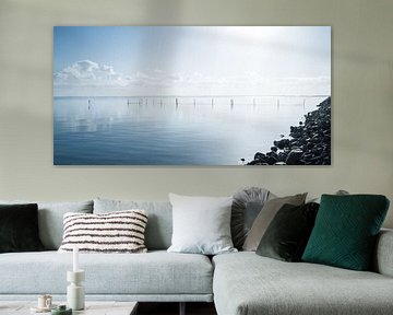 Hollands waterlandschap met reflectie van wolken en fuikpalen. van MICHEL WETTSTEIN