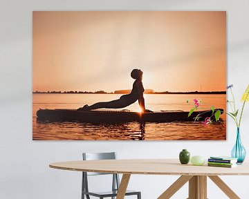 Yogapose als silhouette tijdens de ondergaande zon op een sup board van Mijke Bressers