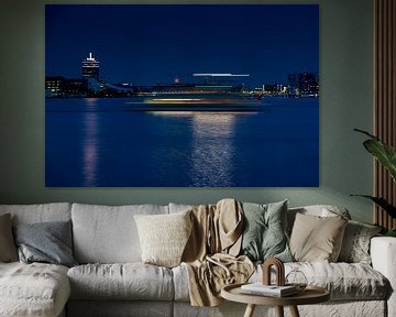 Part of the Amsterdam skyline with stripes of light in evening light by Wim Stolwerk