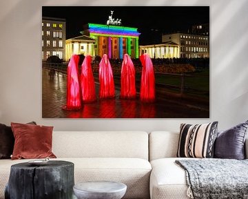 Fünf rote Skulpturen vor dem beleuchteten Brandenburger Tor