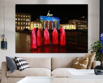 Fünf rote Skulpturen vor dem beleuchteten Brandenburger Tor