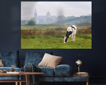 Cow grazing in Bossche Broek with St John's Cathedral in background by Sander Groffen