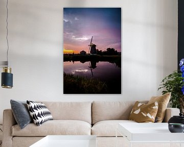 Sunset on a dike in west friesland with a windmill in the background