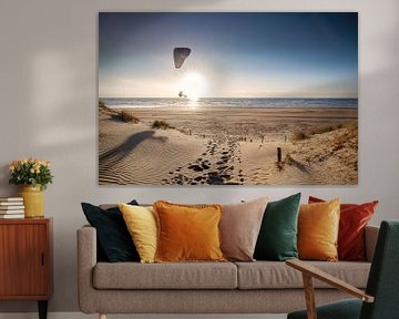 man paragliding on beach at sunset in summer by Olha Rohulya