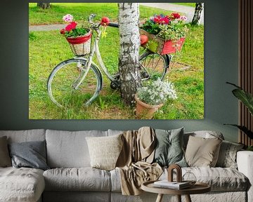 Une bicyclette décorée de fleurs s'appuie contre un arbre. sur Gunter Kirsch
