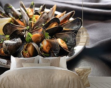 Freshly cooked blue mussels with lemon and parsley garnish on a plate, dark napkin and slate table,  by Maren Winter