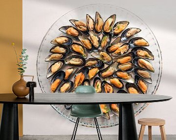 Mit Zwiebeln und Kräutern gekochte Muscheln, serviert auf einer runden Glasplatte, grauer Hintergrun von Maren Winter