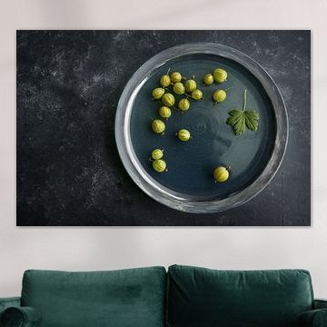 Quelques groseilles à maquereau biologiques fraîchement récoltées sur une plaque bleu foncé et un fo sur Maren Winter