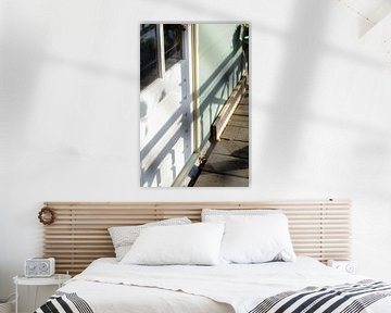 Der Schatten eines Zauns auf einem blauen Haus