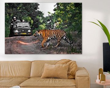 Een tijger steekt de weg over voor een jeep. van Michael Semenov