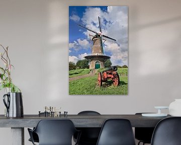 Traditionele Nederlandse windmolen op met een oude rode canon vooraan van Tony Vingerhoets