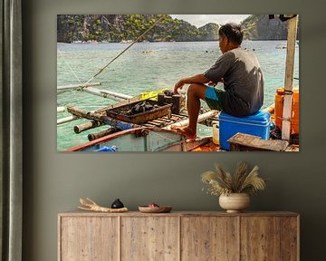 Visser bereidt vis op boot (Filipijnen)