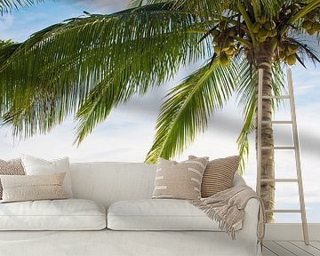 Een ligstoel onder een palmboom op een tropisch strand