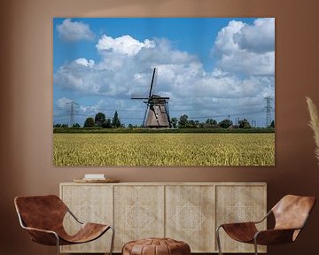 Landscape with beautiful traditional Dutch windmill with blue sky and clouds.