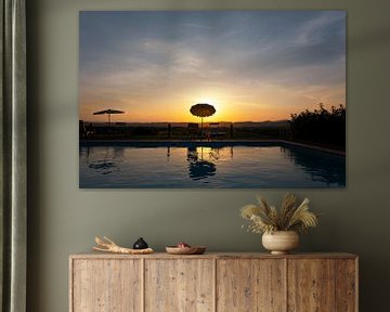 Ein Sonnenuntergang mit Pool und blauem Wasser in der Toskana, Italien.