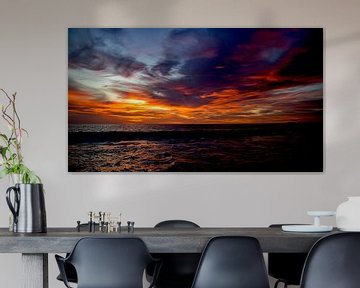 A beautiful cloud sky full of color at the time of sunset on the beach of Bonaire by Hans de Waay