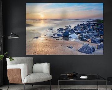 Golfbrekers met strand bij een zonsondergang van eric van der eijk