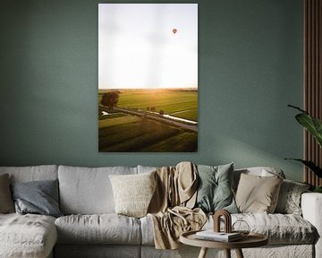 Heißluftballon schwebt über einer niederländischen Landschaft von Moniek Kuipers