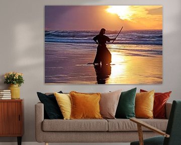 Jonge samurai vrouw met Japans zwaard Katana)  met zonsondergang op het strand van Eye on You