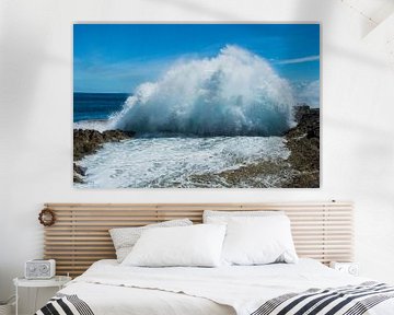 Waves splash high up against a rocky coast by Hugo Braun