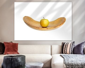 Zijaanzicht van een platte houten schaal met een appel in het midden blootgesteld aan wit van Hans-Jürgen Janda