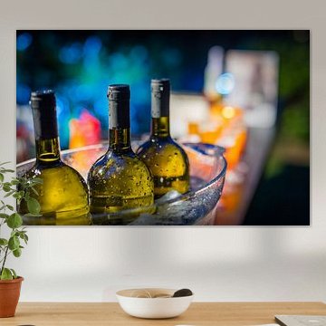 Three bottles of wine in an ice bucket.