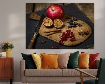 Schneidebrett aus Holz mit Granatapfel, Passionsfrucht, Beeren, Zimtstangen und Sternanis von Mayra Fotografie