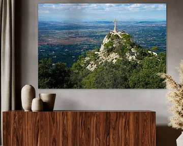 Blick von Sant Salvador (Mallorca) auf eine Kreuzstatue vor Landschaft mit Bergen im Hintergrund