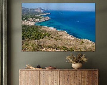 Blick auf das Meer an der Cala Mesquida auf Mallorca mit Bäumen und Büschen im Vordergrund