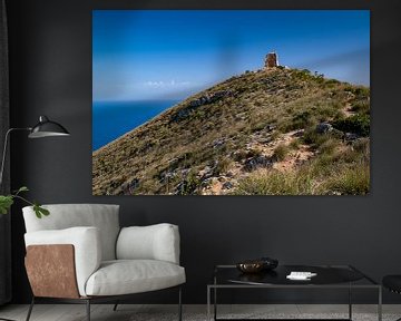 Hill overgrown with green bushes and tower ruins near Cala Agulla on Mallorca by Hans-Heinrich Runge