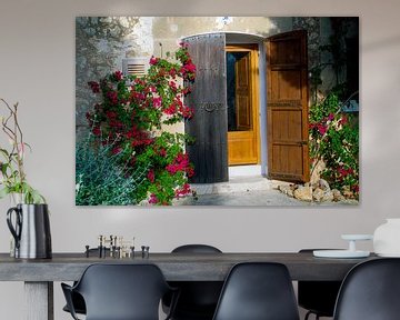 Malerische Haustür auf Mallorca von roten Blüten umrankt