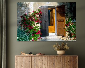 Malerische Haustür auf Mallorca von roten Blüten umrankt