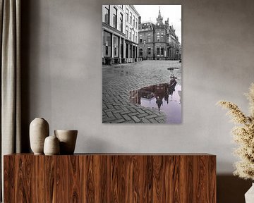 Zwartwit foto van toren aan de Pausdam in Utrecht met gekleurde weerspiegeling in de plas. van Phillipson Photography