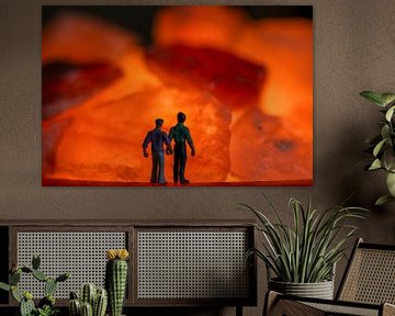 Männer zusammen Hand in Hand mit Blick auf die orange Feuer in Steinen von Jolanda de Jong-Jansen