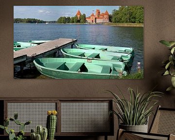 Zicht op het Trakai kasteel met op de voorgrond kleurrijke roeibootjes aan een steiger van Gert Bunt