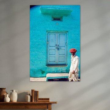 Indian man passes a house.