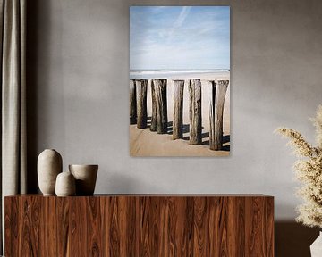 Foto van houten palen op het strand van Schoorl | zonnige kust in Nederland van Evelien Lodewijks