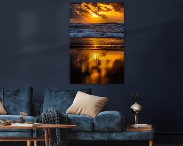 reflectie van ondergaande zon op het strand van Noordwijk
