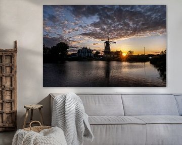Zonsondergang met Nederlandse windmolen in de wateren van Kralingse Plas, Rotterdam, Nederland