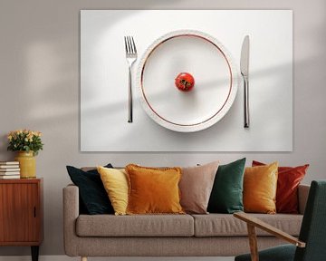 Verse tomaat op een plaat met gouden rand en bestek op een witte achtergrond, dieet met gezonde groe van Maren Winter