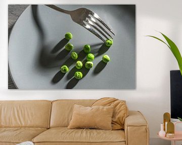 Wat groene erwten en een vork met schaduwen op een grijs bord, magere dieetmaaltijd na het voornemen van Maren Winter